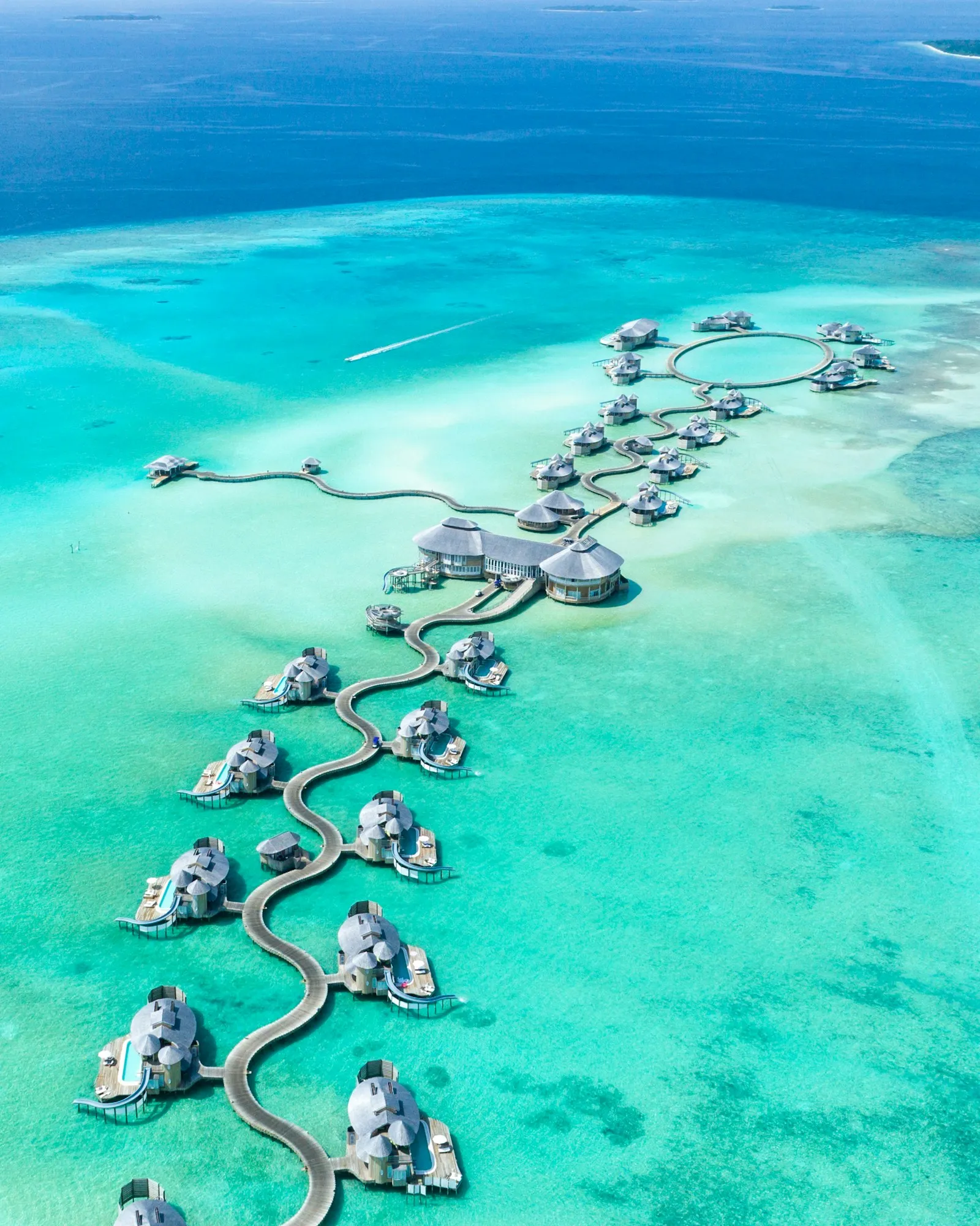Overwater villas stretching across a turquoise lagoon in the Maldives